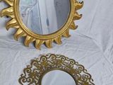 a mirror and a mirror with a gold frame on a white table