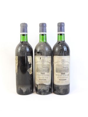 trois bouteilles de vin posées les unes à côté des autres sur une surface blanche
