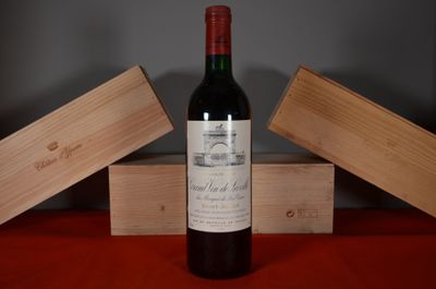 a bottle of wine sitting on a table next to two wooden boxes