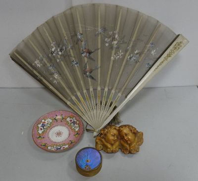 un ventilateur, une bougie et une boîte posés sur une table