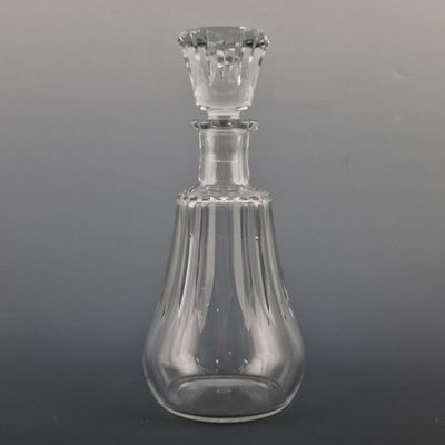 une bouteille en verre transparent avec un bouchon transparent, posée sur une table