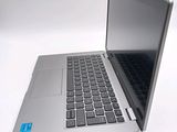 a silver laptop with a black keyboard on a white surface