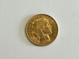 a close up of a gold coin on a white surface