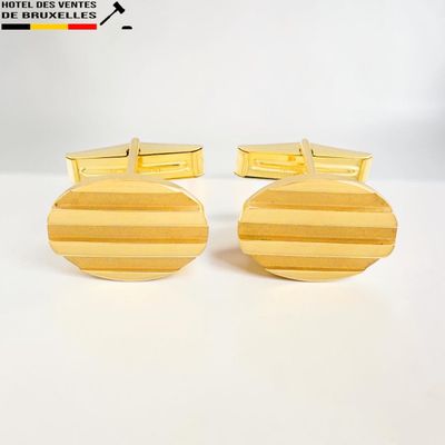 une paire de boutons de manchette à rayures jaunes sur fond blanc