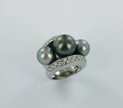 une bague en perle noire et diamants sur fond blanc