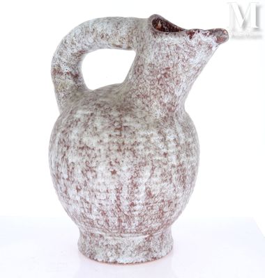 un vase blanc et marron muni d'une anse, posé sur une table
