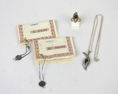 deux colliers et une bague posés sur une table blanche
