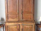 une photo d'une armoire en bois à deux portes, surmontée d'une lampe