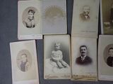 several old photographs of men and women are displayed on a table
