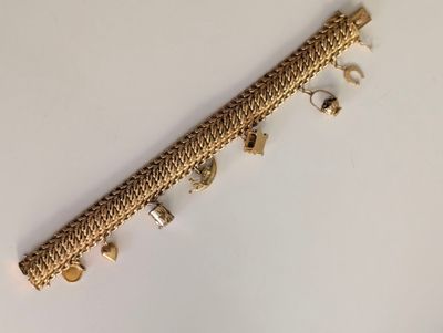 a close up of a gold bracelet on a white surface