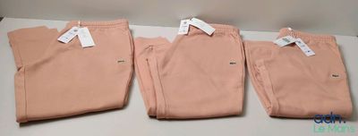 trois paires de pantalons roses posées sur une table blanche
