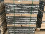 a pile of metal sheets stacked on top of pallets in a warehouse
