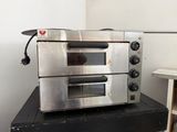 a silver oven sitting on top of a black table