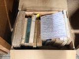 a box full of books sitting on the floor next to a door