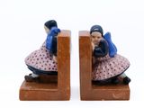 deux figurines représentant une femme assise sur un serre-livres