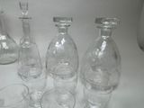 bottles and glasses are lined up on a table with a white background