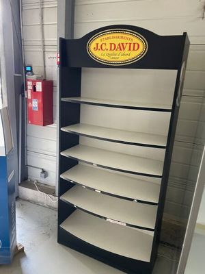a black and white shelf with a sign on it in a garage