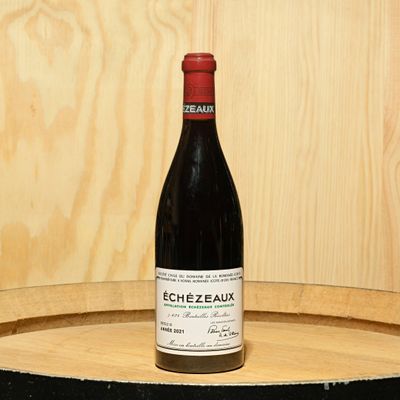 a bottle of wine sitting on top of a barrel