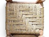 woven wicker chair with wooden legs on a white background