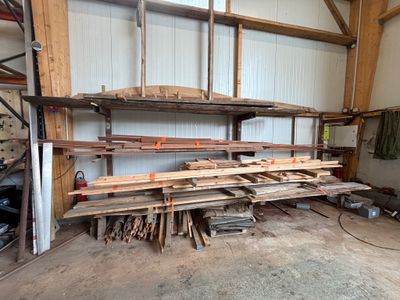 de nombreuses pièces de bois empilées sur les étagères du garage
