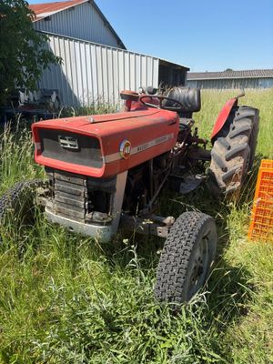 un tracteur rouge assis dans l'herbe
