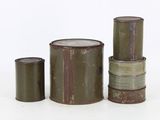 three old tins are stacked on top of each other on a white surface