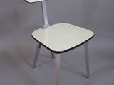 une chaise blanche avec une assise noire sur fond gris