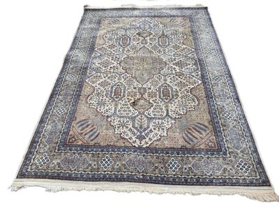 un tapis oriental orné d'un grand médaillon sur fond blanc