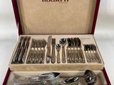 an assortment of silverware in a red box on a white surface