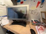 a computer monitor and keyboard on a desk in a cubicle