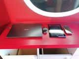 un bureau rouge sur lequel se trouvent un ordinateur portable et une souris