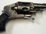 un vieux revolver avec une crosse noire sur un fond blanc