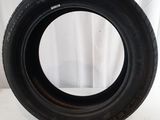 a close up of a tire on a white surface with a curtain in the background