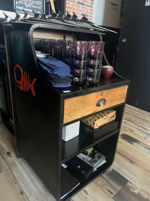 a black and wooden bar cart with glasses on it