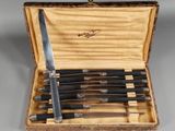 five knives in a case with a wooden handle