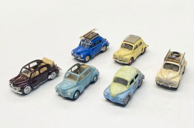 plusieurs petites voitures sont alignées sur une surface blanche