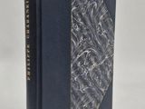un livre à la couverture noire posé sur une table blanche