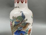 a white vase with a bird and flowers on it