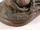 a statue of a cat sitting on top of a shoe