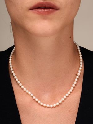 un gros plan d'une femme portant un collier de perles
