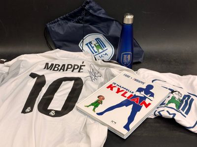 un maillot de foot, une gourde, un livre et un sac posés sur une table