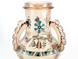 a gold vase with a blue flower on it