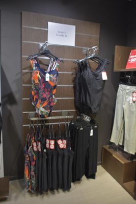 a display of clothing in a clothing store with clothes on hangers