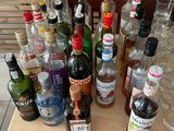 many bottles of alcohol sitting on a table next to each other