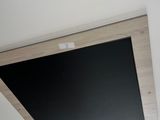 un téléviseur fixé au plafond au-dessus d'un lavabo