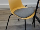a yellow chair sitting next to a desk with a laptop on it