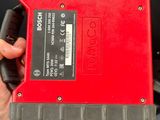 une personne tenant un objet rouge et noir dans la main