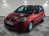 une photo d'une Ford Fiesta rouge garée dans un garage