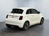 the small white car is parked in a large room