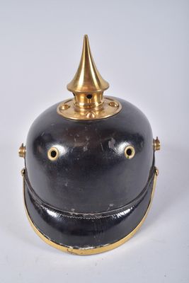 une cloche ancienne en laiton et noir, surmontée d'un capuchon doré